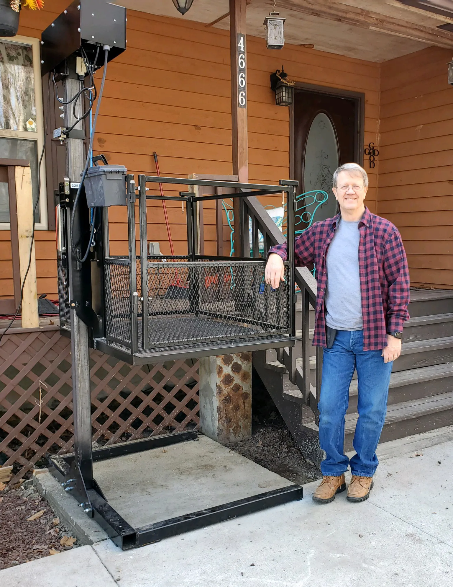 Outdoor vertical platform lift beside a lakeside home